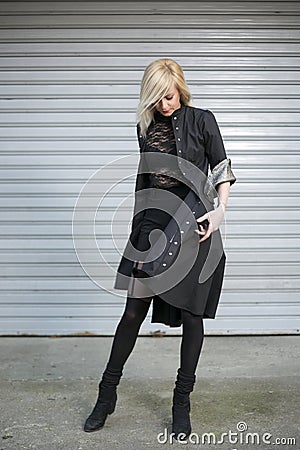 Portrait of beautiful fashionable long blonde hair girl wearing elegant dress in front of street background Stock Photo