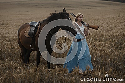 Portrait of a beautiful female cowgirl with shotgun from wild west riding a horse in the outback. Stock Photo