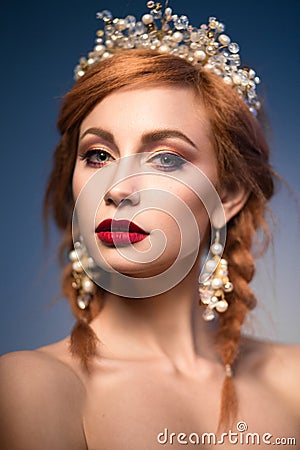 Portrait of a beautiful ginger woman with crown and red lips in the image of the bride. Stock Photo