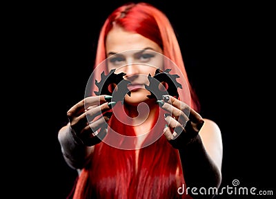 Portrait of beautiful girl with circular saw blade. Bretty naked woman, long red hair, nude body, sawblade, dark background Stock Photo