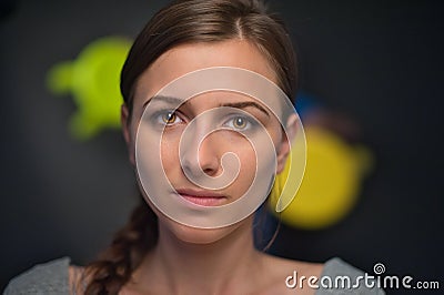 Portrait of a beautiful girl on a dark soft coloured background, which with a serious face Stock Photo