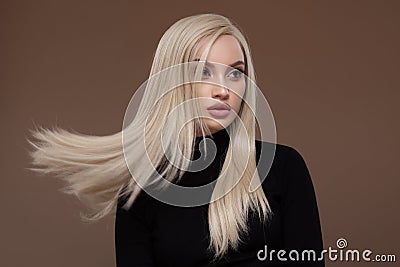 Portrait of beautiful girl with long airy hair. Brown background Stock Photo