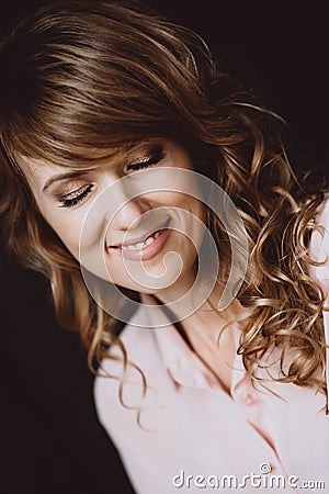 Portrait of a beautiful girl 36 years old with curly hair and an open playful smile and white teeth and eyes closed. Soft Stock Photo