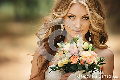 Portrait of beautiful luxury bride with roses wedding bouquet outdoors. Young woman with professional make up and hair style. Stock Photo