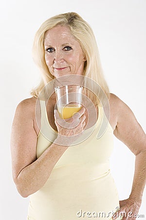 Portrait of a beautiful mature woman enjoying a glass of orange juice Stock Photo