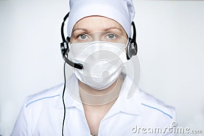 Portrait of a beautiful medical woman wearing protective mask with handset Stock Photo