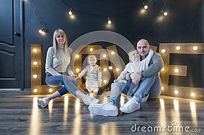 Portrait of beautiful mommy, daddy and lovely kids in studio. Stock Photo