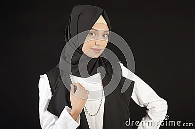 Portrait of a beautiful Muslim woman in modern oriental clothes on an isolated black background Stock Photo