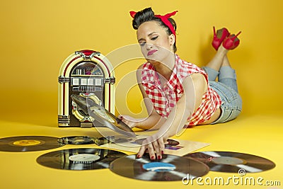 Portrait beautiful pin up listening to music on an old jukebox r Stock Photo