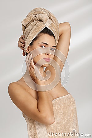 Portrait of a beautiful posh young woman after bath standing covered in towel looking at camera. Stock Photo