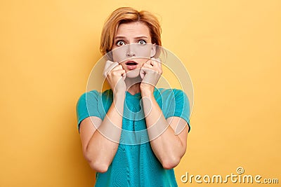 Portrait of beautiful puzzled blonde girl isolated on yellow studio Stock Photo