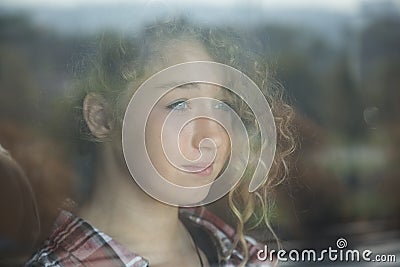 Portrait of Beautiful Redhead Girl Behind Glass with reflection Stock Photo