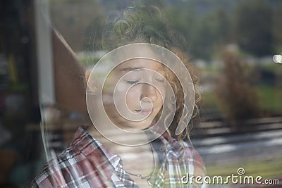 Portrait of Beautiful Redhead Girl Behind Glass with reflection Stock Photo