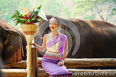 Portrait of Beautiful rural thai woman wear Thai northern traditional dress acting for phot shoot with Asian elephant on blurred Stock Photo