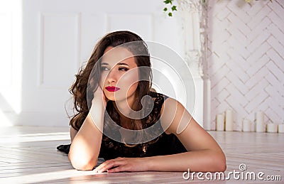 Portrait of beautiful sensual young woman. Beautiful thoughtful brunette in white room. Beautiful elegant woman posing on white Stock Photo