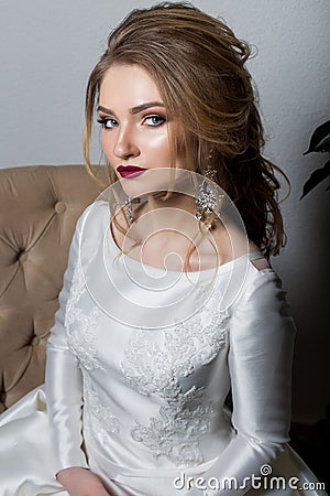 Portrait of a beautiful cute girl happy bride in an elegant dress with bright makeup in a white dress with a gorgeous wedding Stock Photo