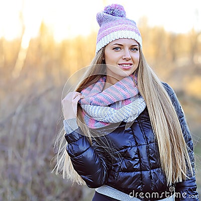 Portrait of beautiful smiling blonde woman in down jacket outdoors Stock Photo