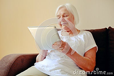 Portrait of beautiful smiling senior woman with the ipad Stock Photo