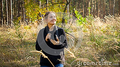 Portrait of beautiful smiling woman with digital camera working as photographer in forest Stock Photo