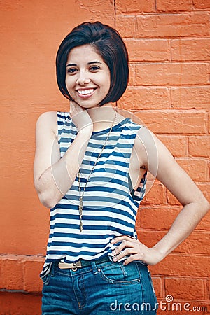 Portrait of beautiful smiling young hipster latin hispanic girl woman with short hair bob, in blue jeans, striped tshirt Stock Photo