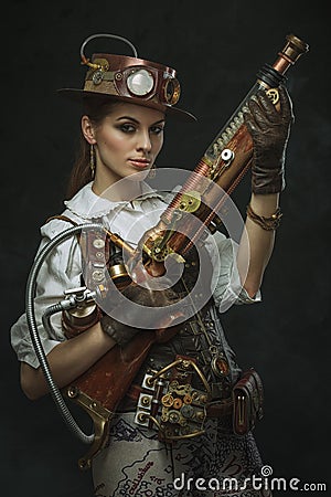 Portrait of a beautiful steampunk woman holding a gun Stock Photo