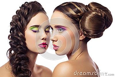Portrait of beautiful twins young fashion women with hairstyle and red pink green makeup. isolated on white background. Stock Photo
