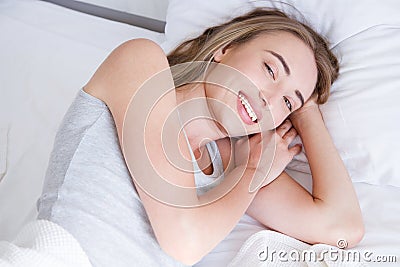 Portrait of beautiful woman awakening in her white bed and yawning.Rest,sleeping,people and comfort concept. Stock Photo