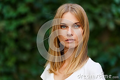 Portrait of beautiful woman on background green trees Stock Photo