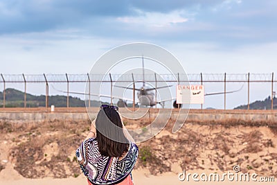 Portrait of Beautiful Woman is Capturing Photos The Airplane While Take off Landing on Runway Track. Tourist Woman Having Fun With Stock Photo