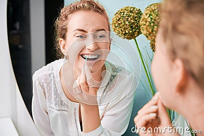 Portrait of woman with braces demonstrating interdental brushing Stock Photo