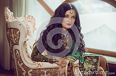 Portrait of a beautiful woman in Indian traditional Chinese dress, with her hands painted with henna mehendi. Stock Photo