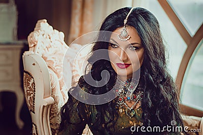 Portrait of a beautiful woman in Indian traditional Chinese dress, with her hands painted with henna mehendi. Stock Photo