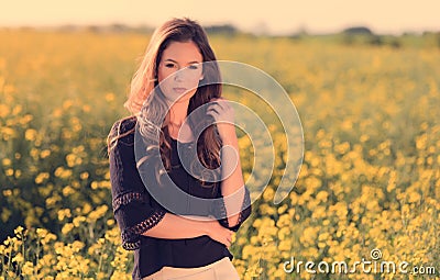 Portrait of beautiful woman in rapeseed field Stock Photo