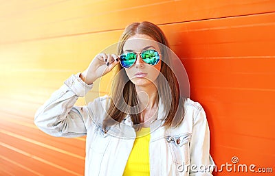 Portrait beautiful woman in sunglasses over colorful orange Stock Photo