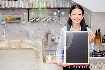 Portrait of beautiful young barista, asian woman is a employee standing holding chalkboard Stock Photo