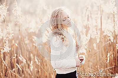 Portrait of a beautiful young blonde girl in a field in white pullover, smiling with eyes closed, concept beauty and health Stock Photo