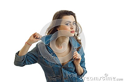 Portrait of a beautiful young brunette in jeans jacket that looks right and keeps hand collar Stock Photo