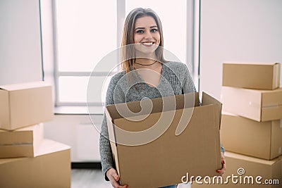 Portrait of beautiful young brunette packing carrying some boxes to move into her new home Stock Photo