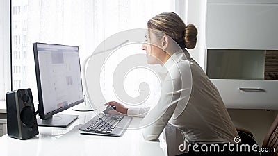 Portrait of beautiful young businesswoman browsing internet on PC at office Stock Photo