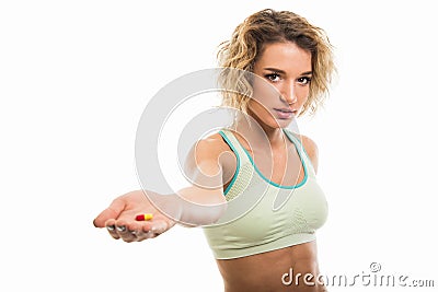 Portrait of beautiful young fit girl handing one pill Stock Photo