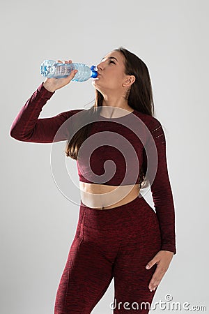 Young beautiful girl with mineral water isolated on white , portrait of beautiful young fit woman drinking water during traning Stock Photo
