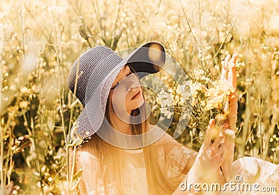 Portrait of a beautiful young girl in a hat against the background of a rapeseed field Stock Photo