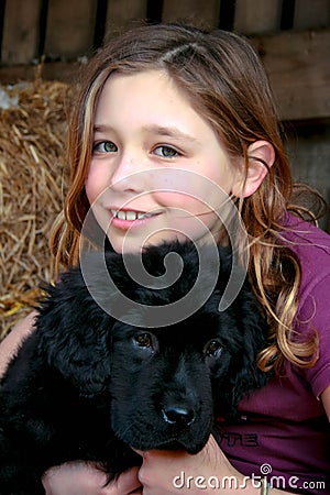 Portrait of a beautiful young girl and her newfoundland puppy hugging Stock Photo