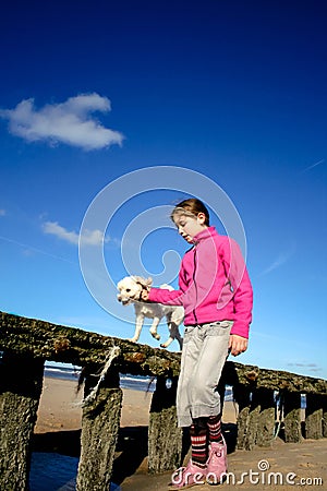 Portrait of a beautiful young girl and her puppy doing balance exercises on the beac Stock Photo