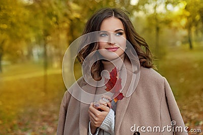 Portrait of a beautiful young happy woman enjoying autumn in the park. Fall season and cute walking lady, romantic portrait Stock Photo