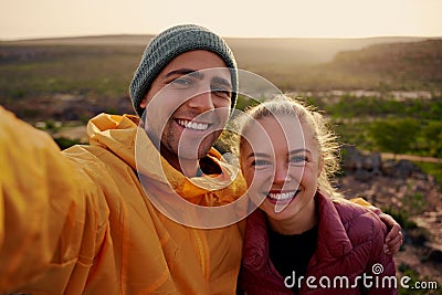 Portrait of beautiful young man and woman hugging and smiling after hiking looking at camera Stock Photo