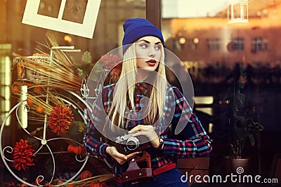 Portrait of beautiful young playful hipster woman with old retro camera. Model looking aside. City lifestyle. Toned Stock Photo