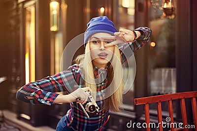 Portrait of beautiful young playful hipster woman with old retro camera. Model looking forvard. City lifestyle. Toned Stock Photo