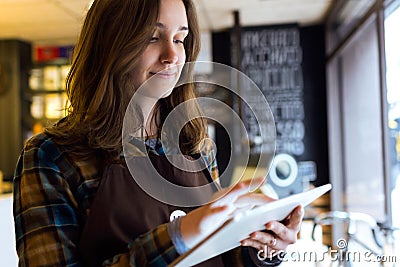 Beautiful young saleswoman using her digital tablet in organic shop. Stock Photo