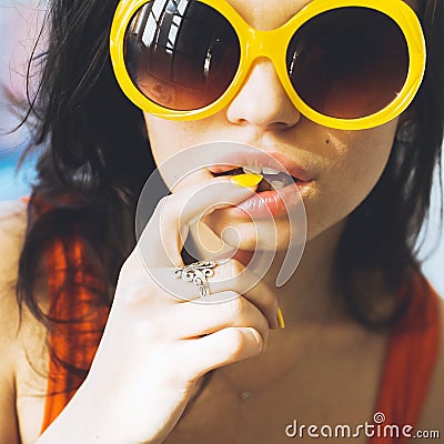 Portrait of a beautiful young brunette girl with expressive eyes and full lips, and sunglasses posing for the camera Stock Photo
